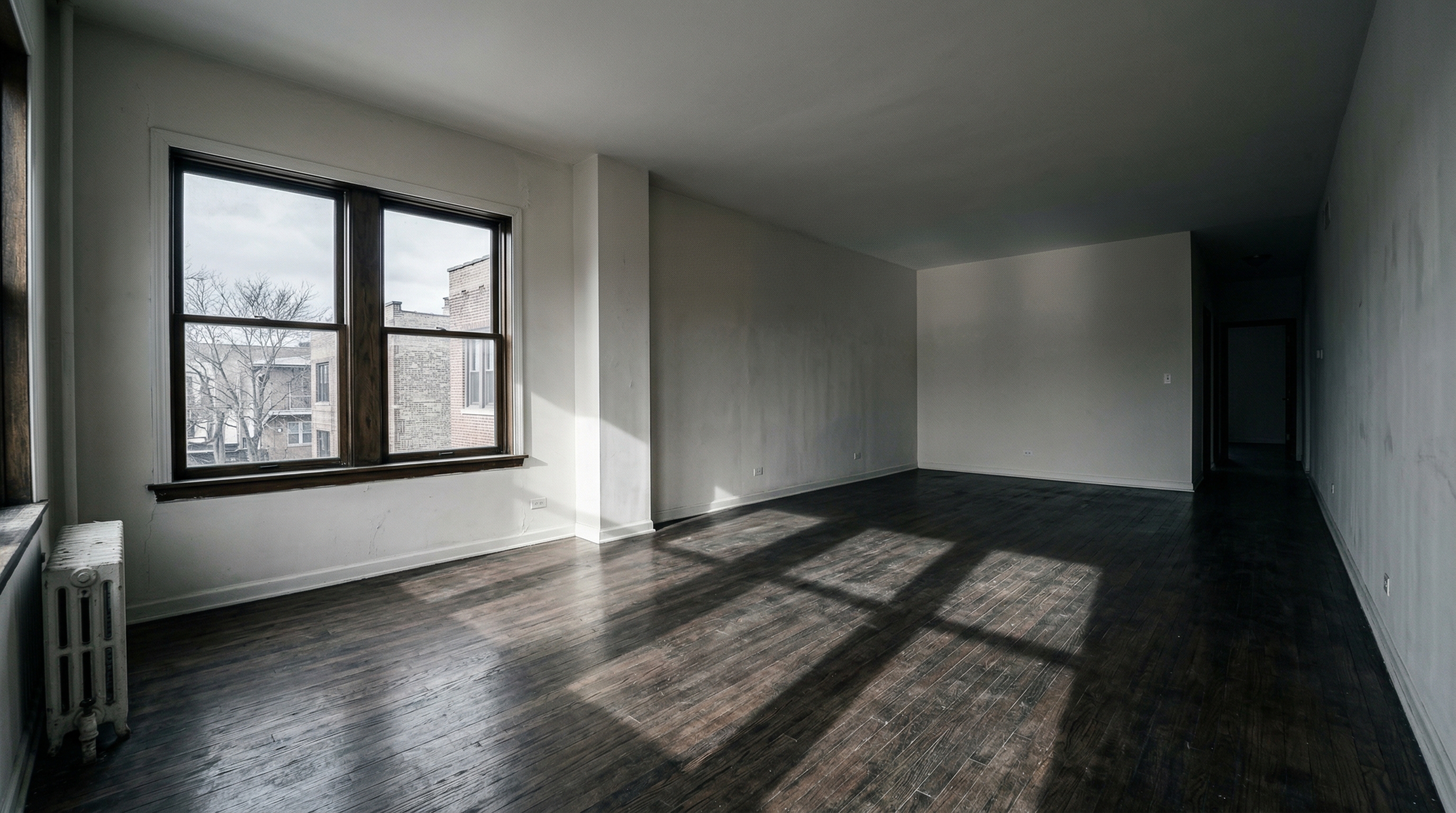 Dark empty room with harsh shadows highlighting the cold feeling of a vacant property